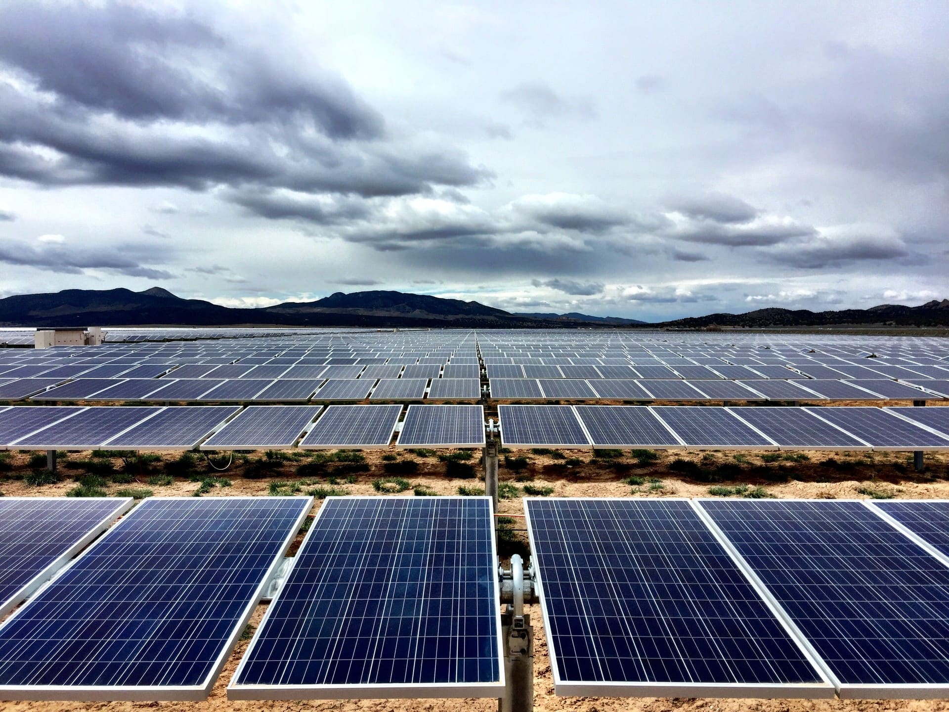 Fileiras de módulos fotovoltaicos até o horizonte, em usina de grande porte em uma usina solar